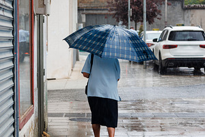 An elderly lady with Umbrella Walking on Rainy Street, Melide, S, a Person Photo by Bepslabor