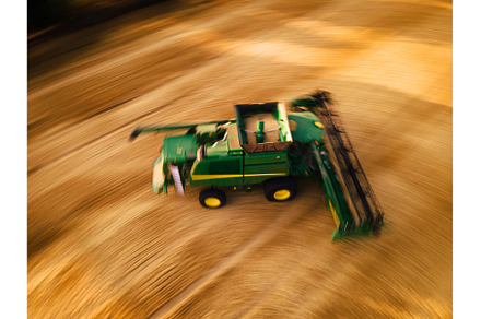 Aerial view of a harvester working, an Industrial Photo by HalfPoint