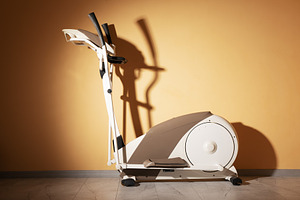 Modern elliptical fitness machine in sunlight, standing on a mar, a Sports & Recreation Photo by Ales Munt