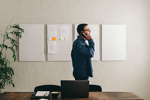 Young businessman talking on the phone in a creative office, a Person Photo by Jacob Lund
