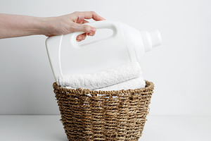 Laundry detergent branding mock up and basket filled with clean white towels. H, a Photo by matucha