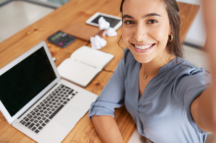 Selfie, laptop and happy woman working at office desk for web tech company success, digital start up and employee smile in office. Smartphone photography, seo manager and happiness at work table, a Photo by Peopleimages.com