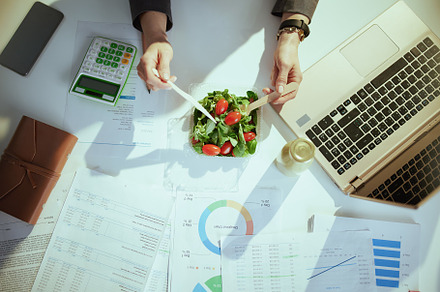 business owner woman in green office eating salad, a Photo by Alliance Images