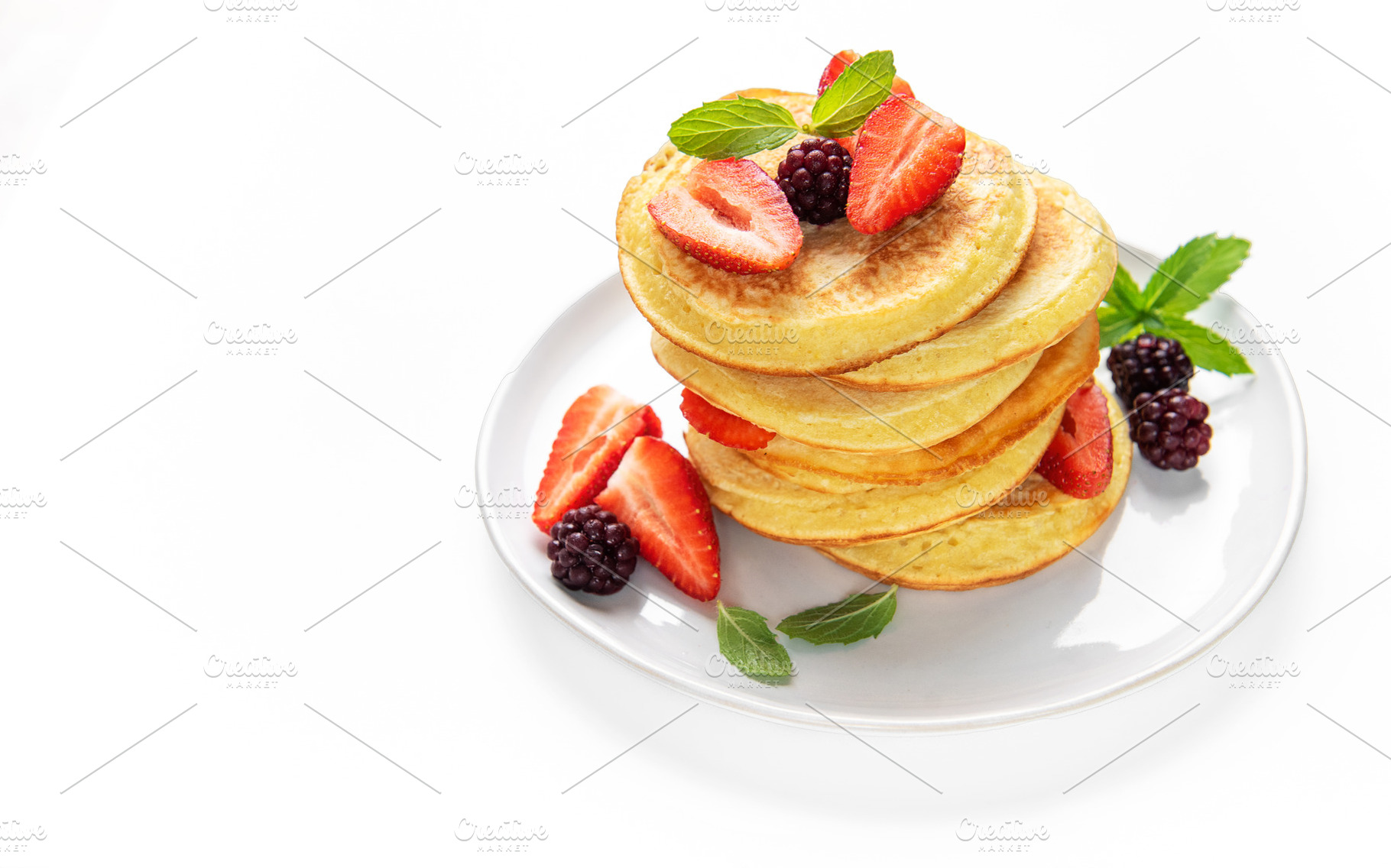 Pancakes stacking with strawberries, blackberries, and mint, a Food & Drink Photo by Olena Rudo