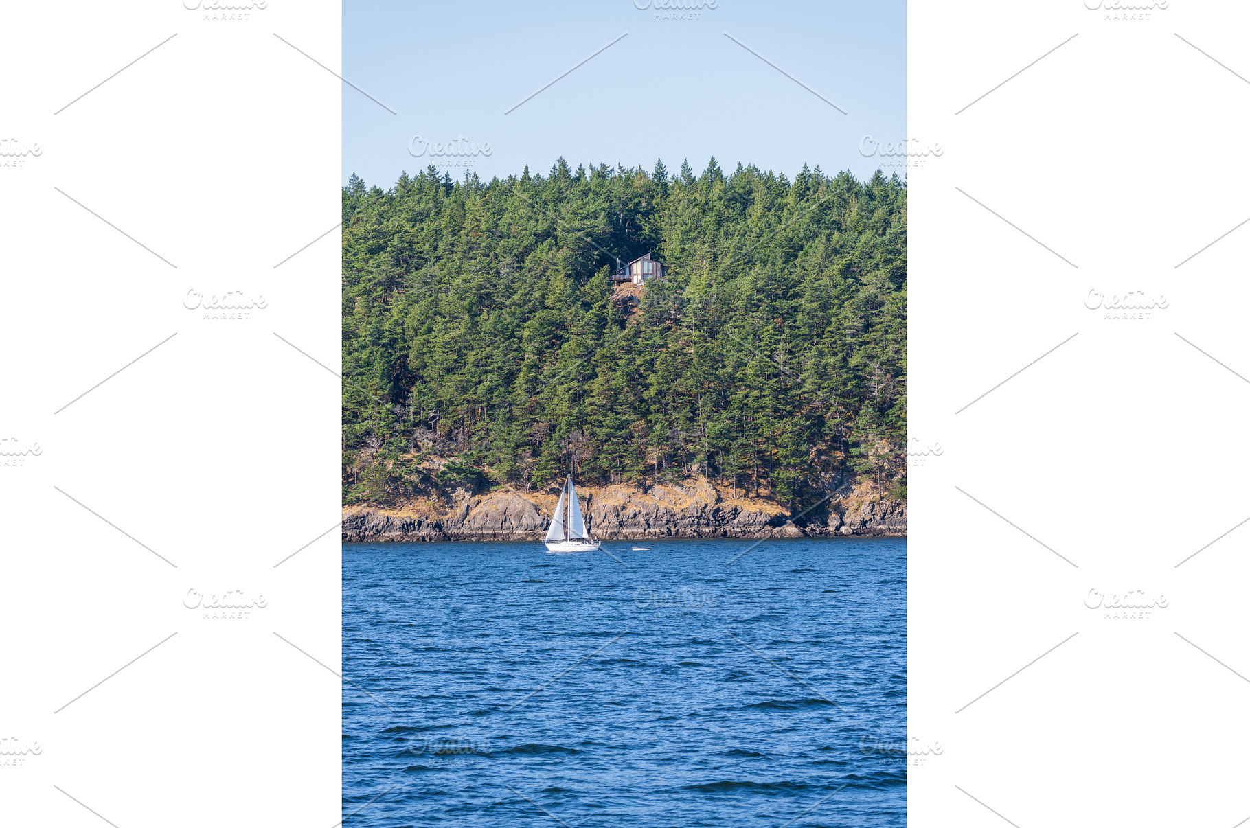 Yacht sailing between two small, a Nature Photo by Backyard Stock