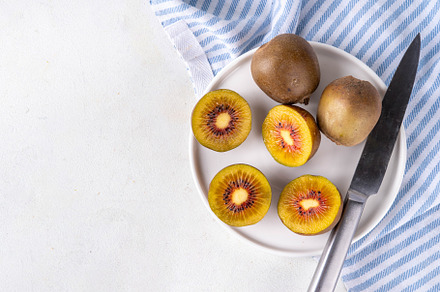Red kiwi, Sweet bright red colored kiwi fruits, whole and sliced, a Food & Drink Photo by Rimma