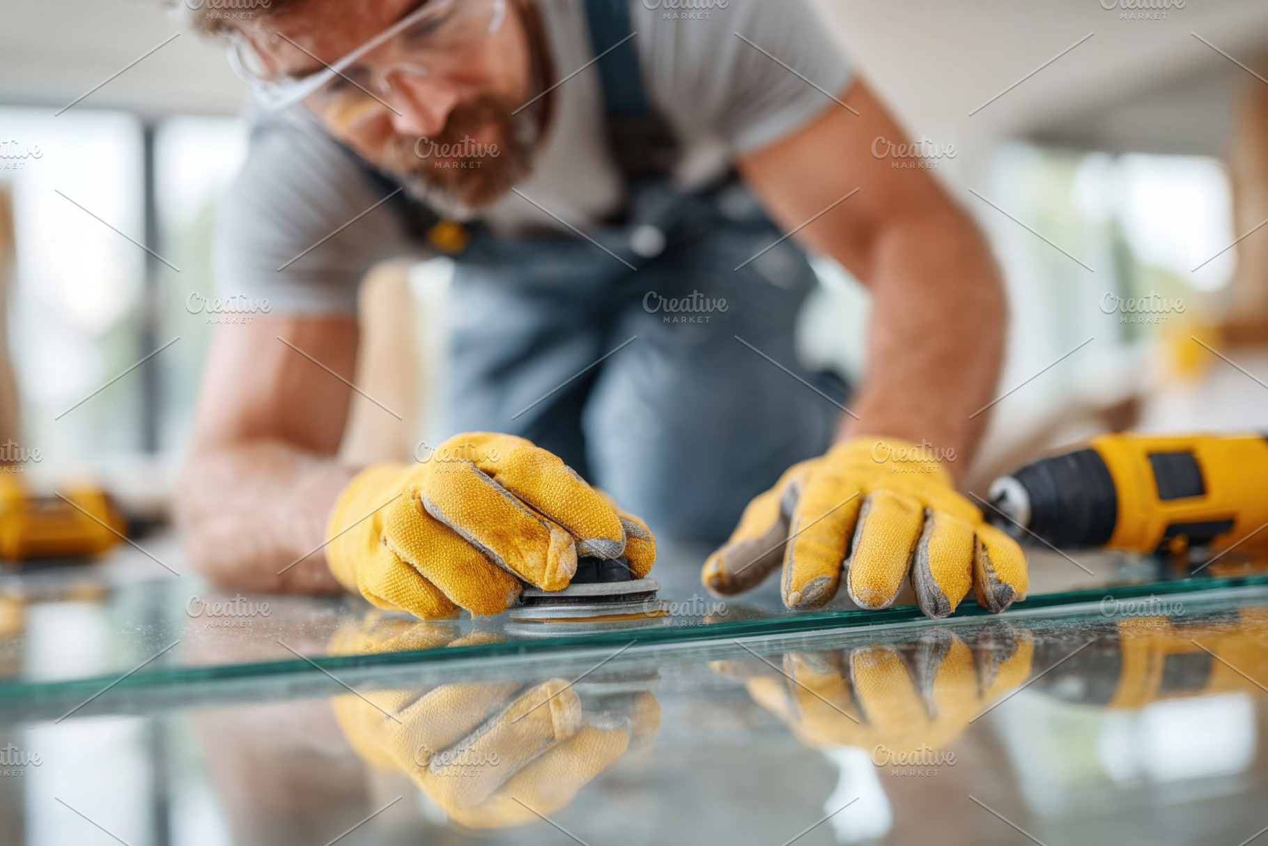 Man working on glass installation with tools, an Industrial Photo by AlyaAnd