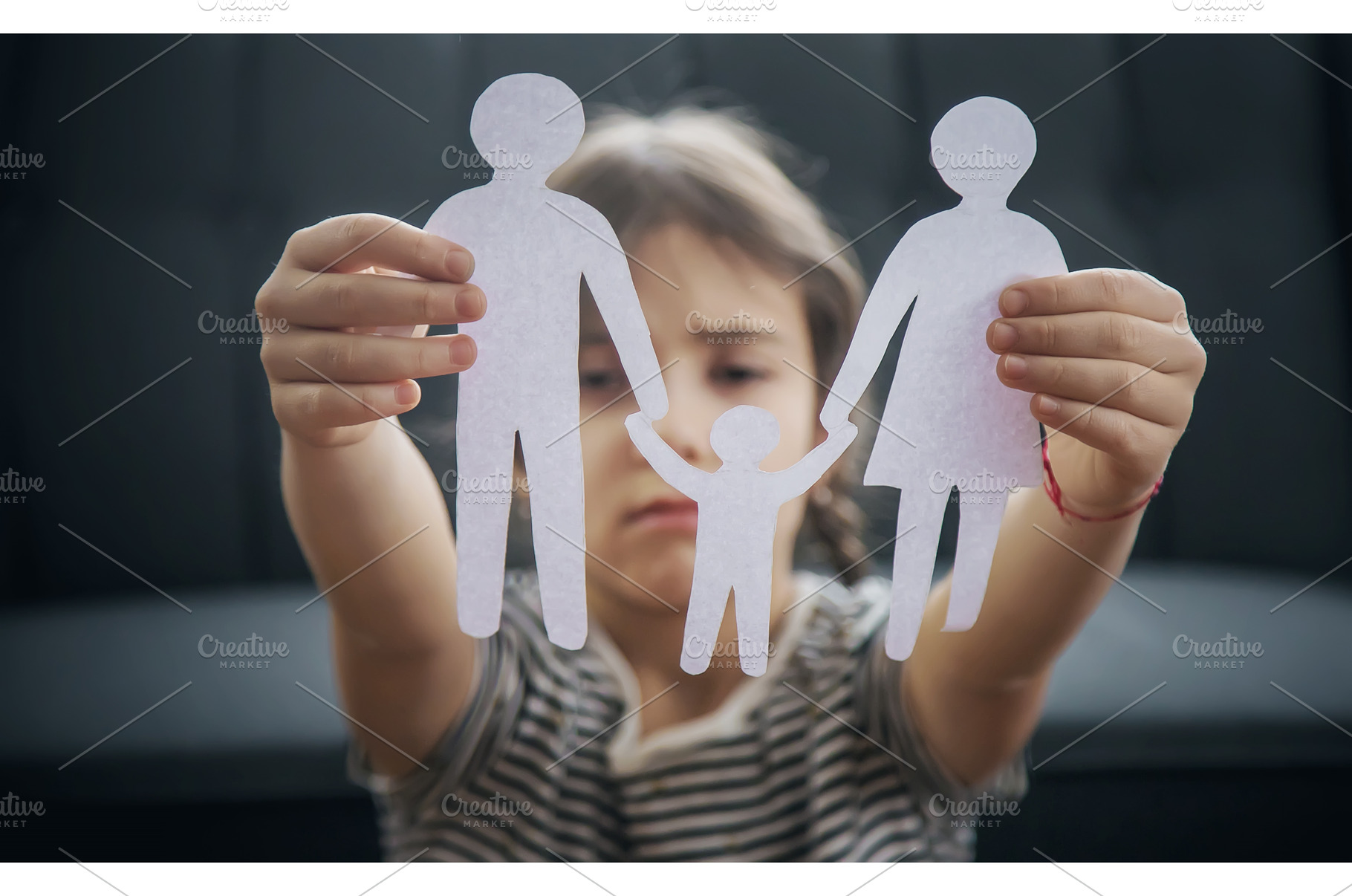 Child with a paper family in his, a Person Photo by yanadjana