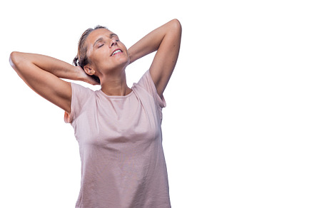 A relaxed adult woman standing with her hands behind head, a Person Photo by Iván Moreno STOCK PHOTO