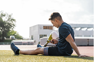Disabled athlete sitting using phone