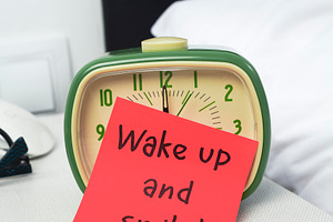 a green alarm clock partly covered by a red note, a Photo by Nito