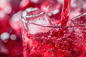 Cherry soda cascading over ice cubes, a Photo by Iftikhar Alam