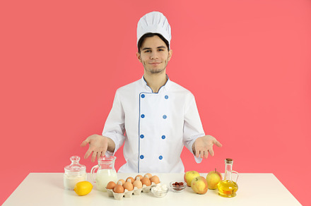 Concept of cooking, young man chef on pink background, a Person Photo by AtlasStudio PRO