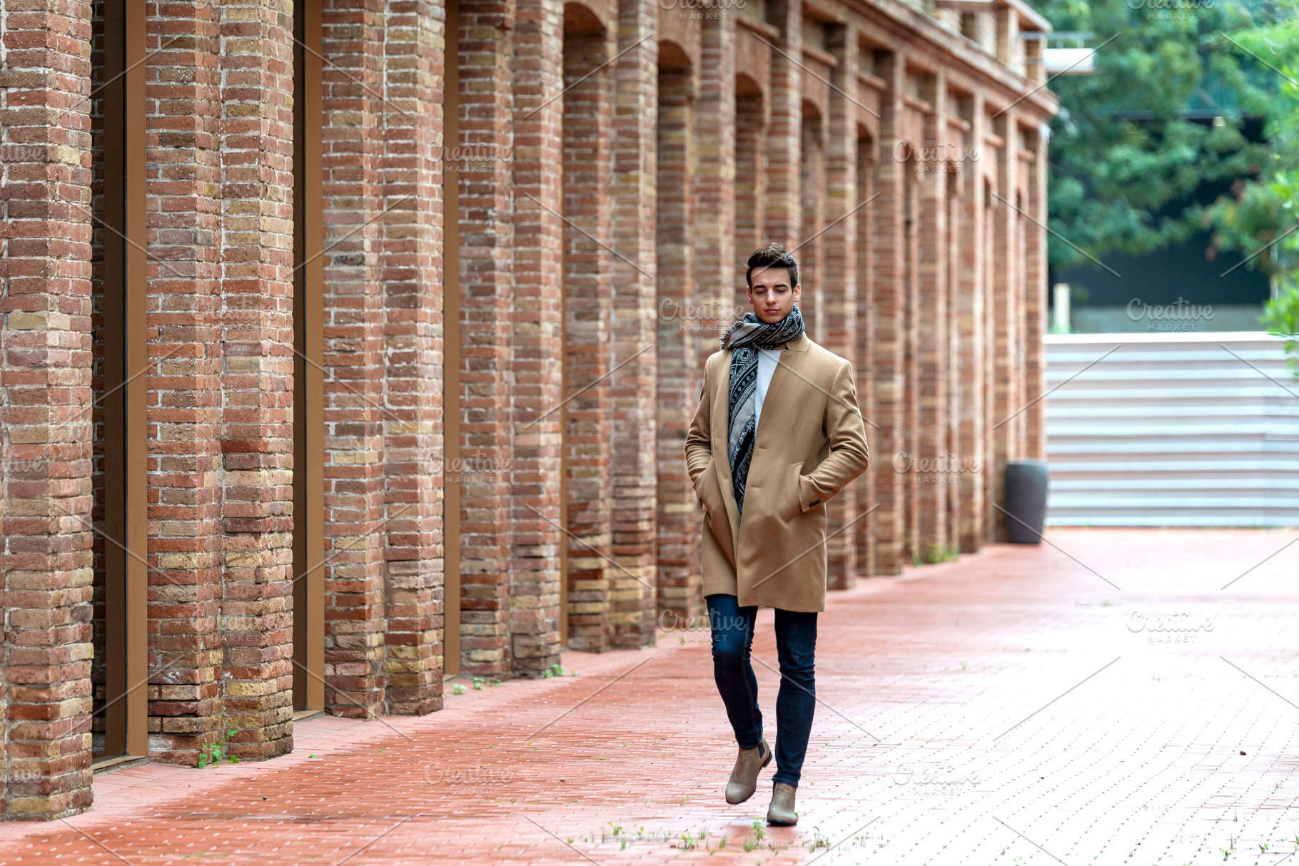 Confident man walking between brick and glass buildings, a Person Photo by RF Images