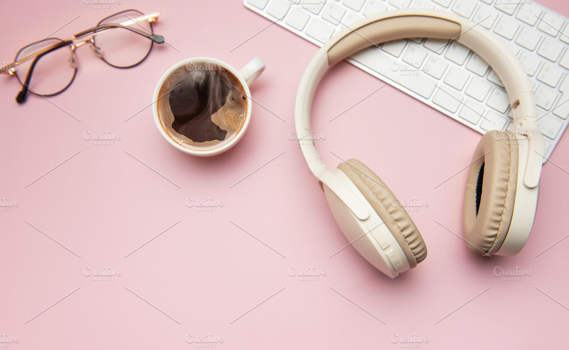 Coffee break accessories on pink table, headphones, keyboard and, a Business Photo by Olena Rudo