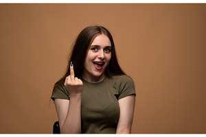 Young woman showing rude middle, a Person Photo by volodymyrshtun13795