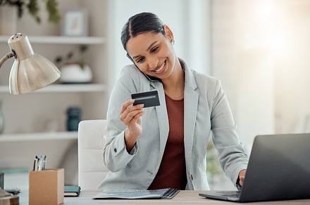 Ecommerce, online shopping and secure banking of happy woman reading credit card while talking on the phone and using laptop. Smiling entrepreneur doing safe financial transaction or transfer payment, a Photo by Peopleimages.com