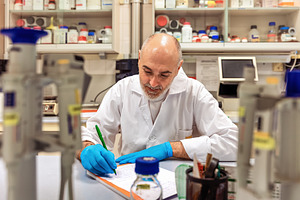 Researcher writing down data in a la, a Health & Medical Photo by Perpis