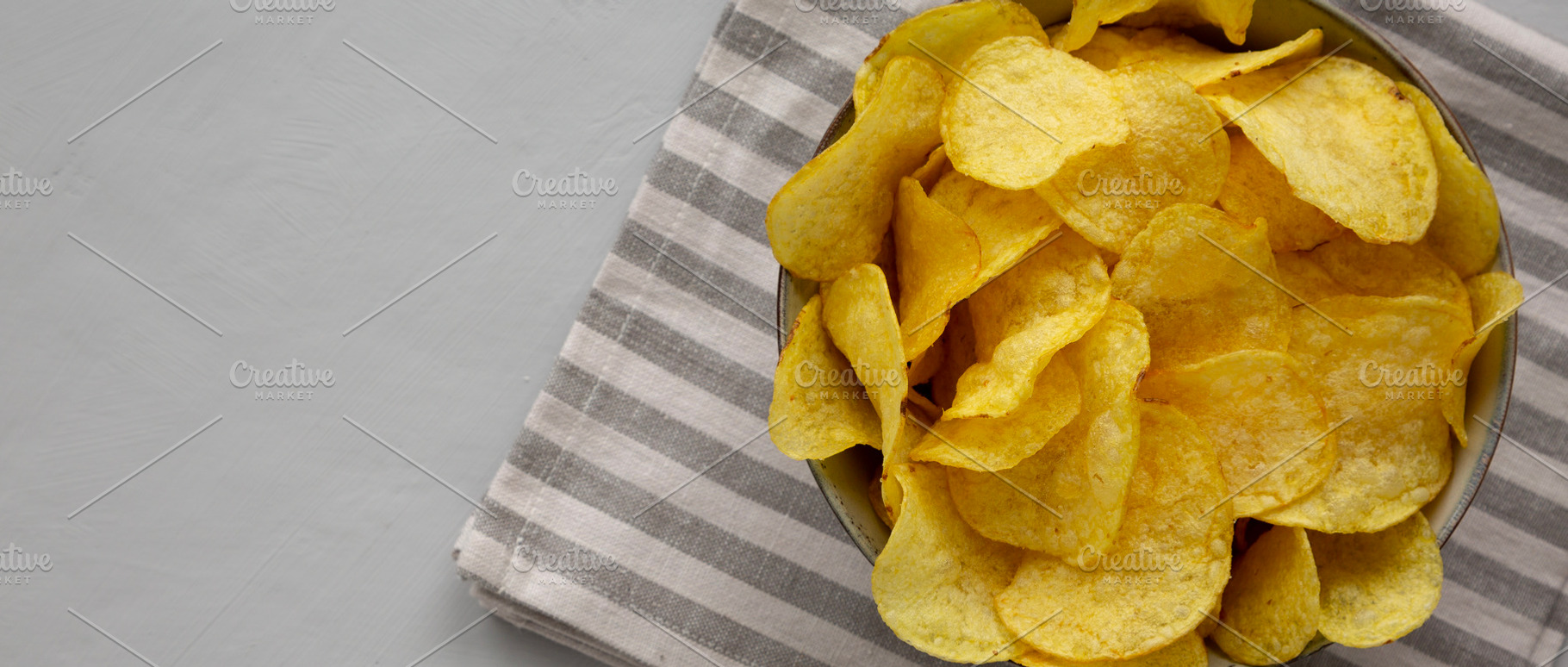 Homemade Kettle Cooked Potato Chips with Salt in a Bowl, top vie, a Food & Drink Photo by LiudmylaChuhunova