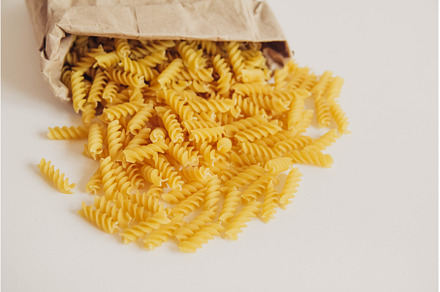 Spiral pasta in a paper bag on a, a Food & Drink Photo by olhovyi_photographer