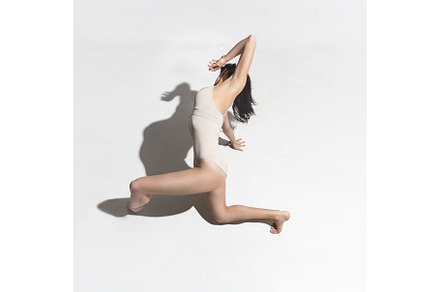 Young beautiful dancer in beige dress dancing on gray background featuring, a Sports & Recreation Photo by Volodymyr Melnyk