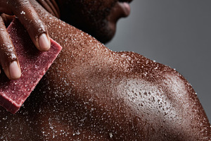 Man scrubs back with soap, a Photo by Beautiful things