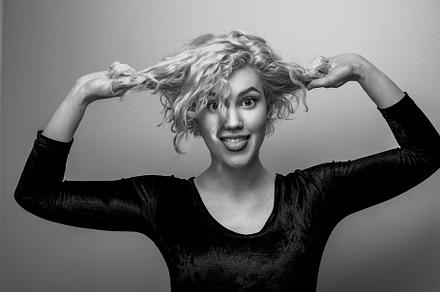 Headshot of gorgeous attractive young lady with curly hair smiling. Black and w