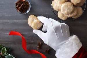 Santa's hand picking up a cookie on dark table, a Food & Drink Photo by Davizro's Market