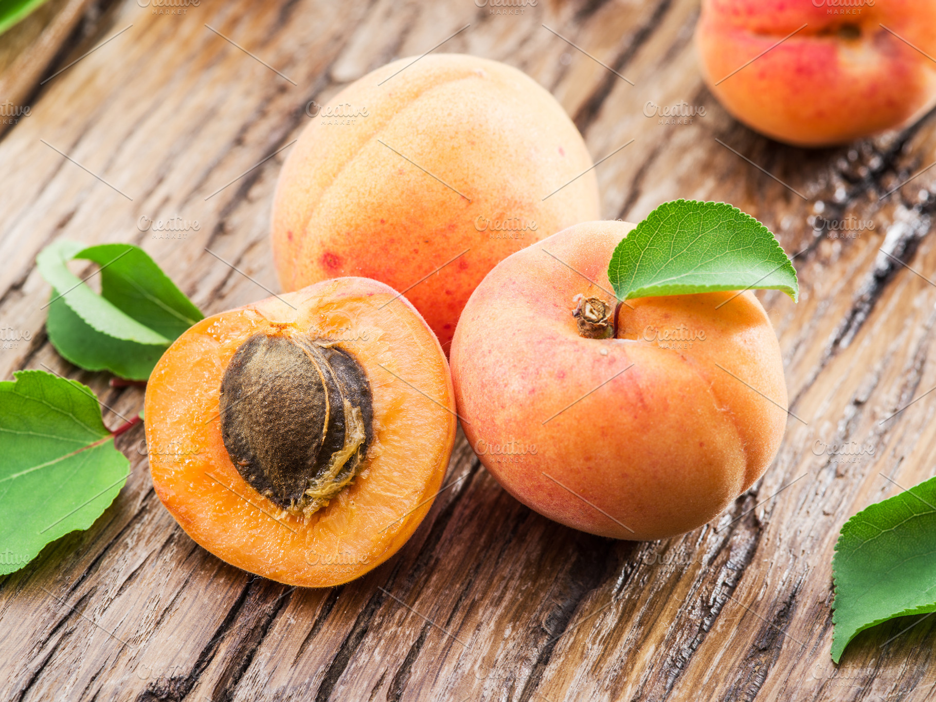 Apricots and its cross-section on the old wooden table., a Food & Drink Photo by Volff