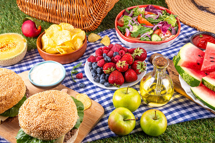 Tasty summer barbecue table with hamburgers, salads, fruits and
