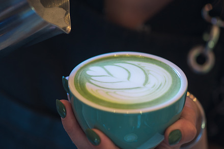 A professional barista woman prepares a green matcha tea latte. Latte art close, a Food & Drink Photo by PavelKant