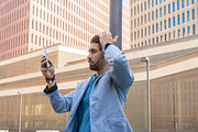 Handsome young man smiling when he is using his mobile phone, a Person Photo by RF Images (Thumbnail 2 of 2)