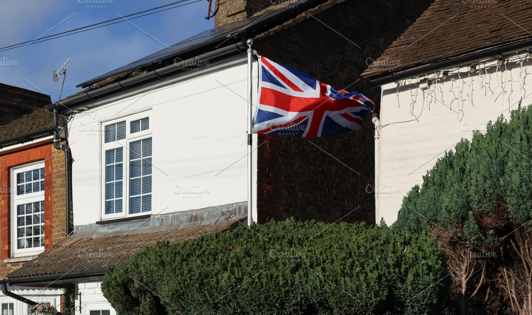 British flag, Union Jack, flapping on a flagpole attached to a h, a Photo by Studio ANNA
