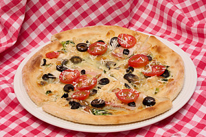Pizza with cheese, tomatoes and olives on a white plate standing, a Food & Drink Photo by ndanko