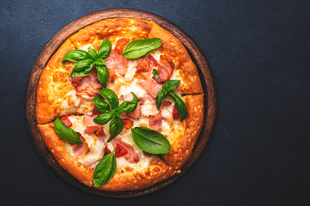 Homemade hot pizza with ham, mozzarella cheese, tomato sauce and