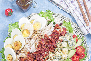 Cobb salad with greens, tomato, avocado, blue cheese, bacon, chicken and eggs,, a Food & Drink Photo by iuliia_n