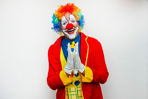 Smiling clown with hands together, a Person Photo by karrastock