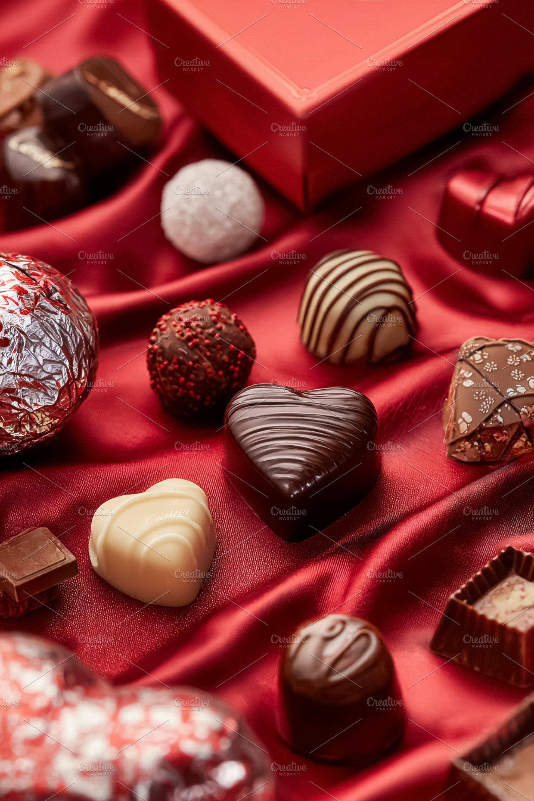 Heart chocolates and truffles on red silk fabric, a romantic Val, a Photo by Studio ANNA