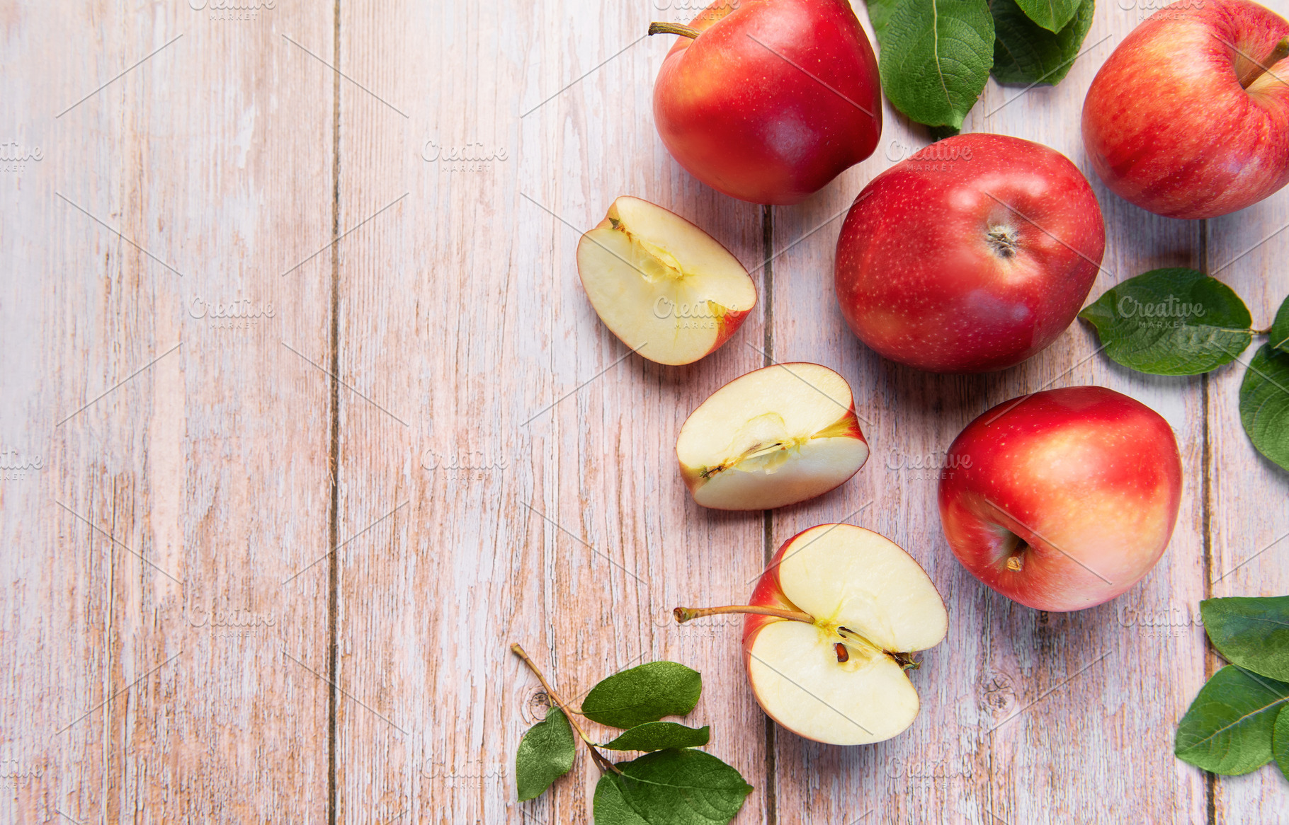 Red apples and slices on light wood background, a Food & Drink Photo by Olena Rudo