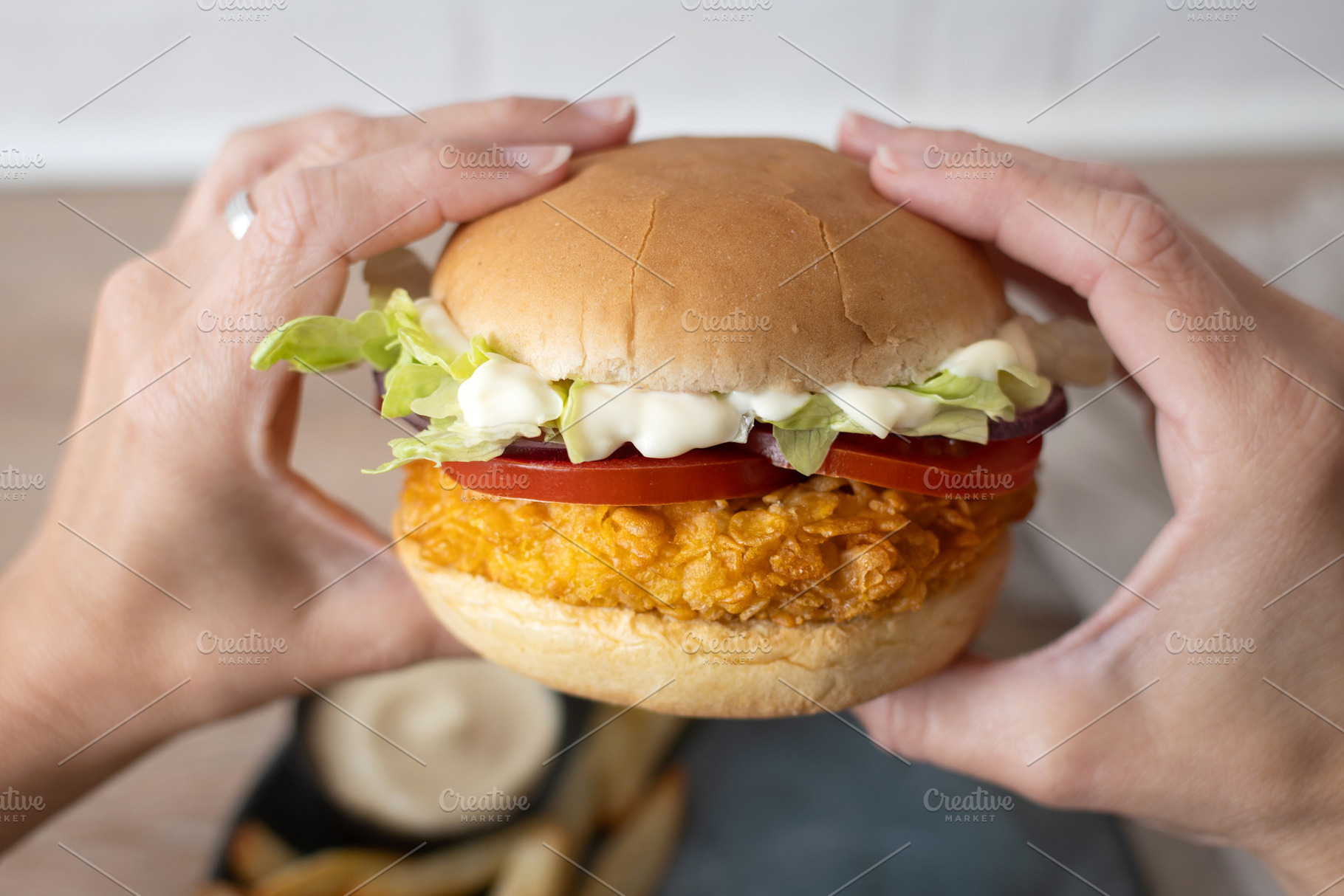 Woman holding crispy chicken burger ready to eat, a Food & Drink Photo by etorres69