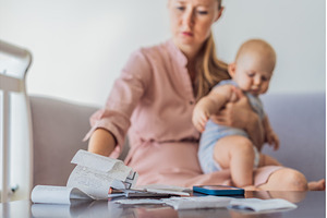 Mother sitting on sofa holding baby