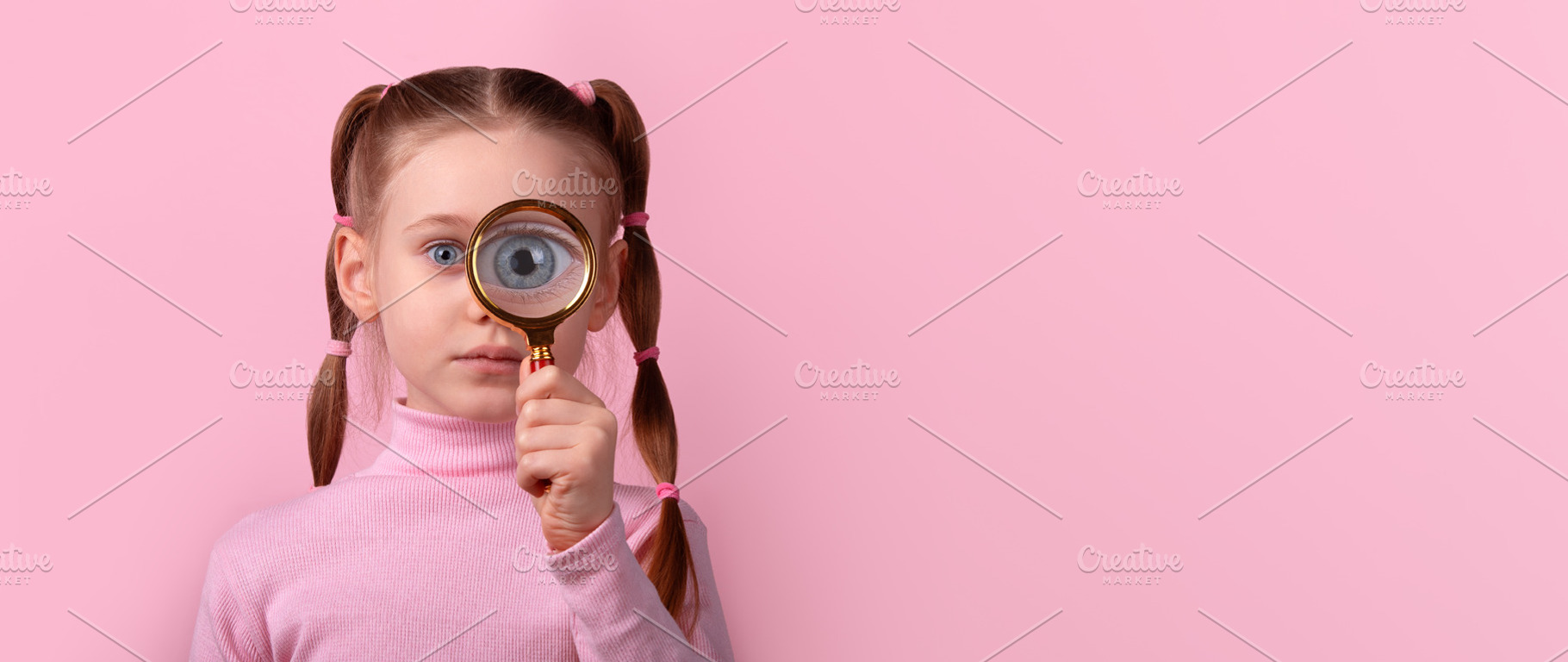 Young girl with pigtails holding magnifying glass to her eye, st, a Person Photo by Ales Munt