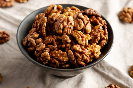 Raw Walnut Halfs in a Bowl, side view.