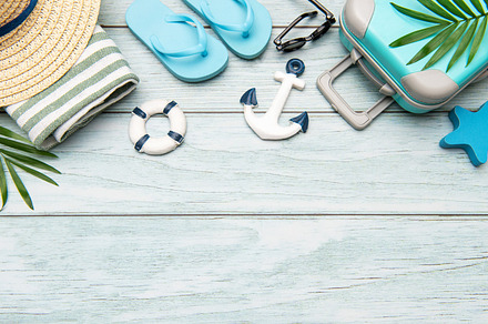 Summer vacation accessories lying on wooden background with copy