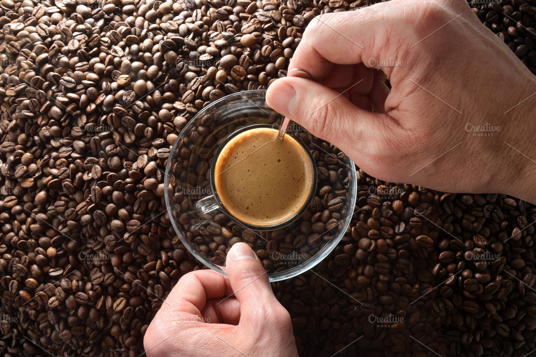 Hands stirring freshly brewed coffee over heap of coffee beans, a Food & Drink Photo by Davizro's Market