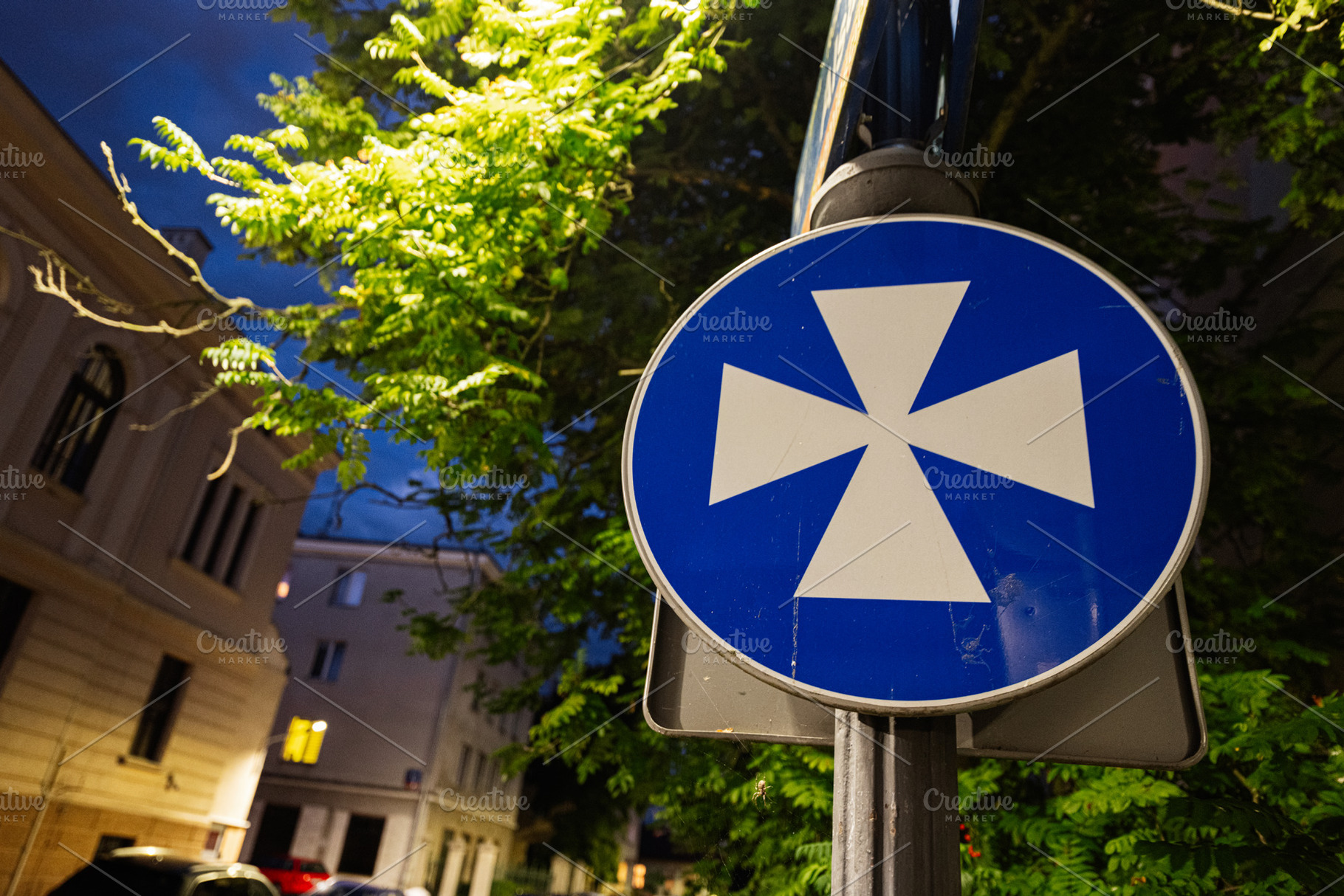 Blue traffic sign with cross symbol in Rzeszow, Poland during evening, a Photo by AS photostudio