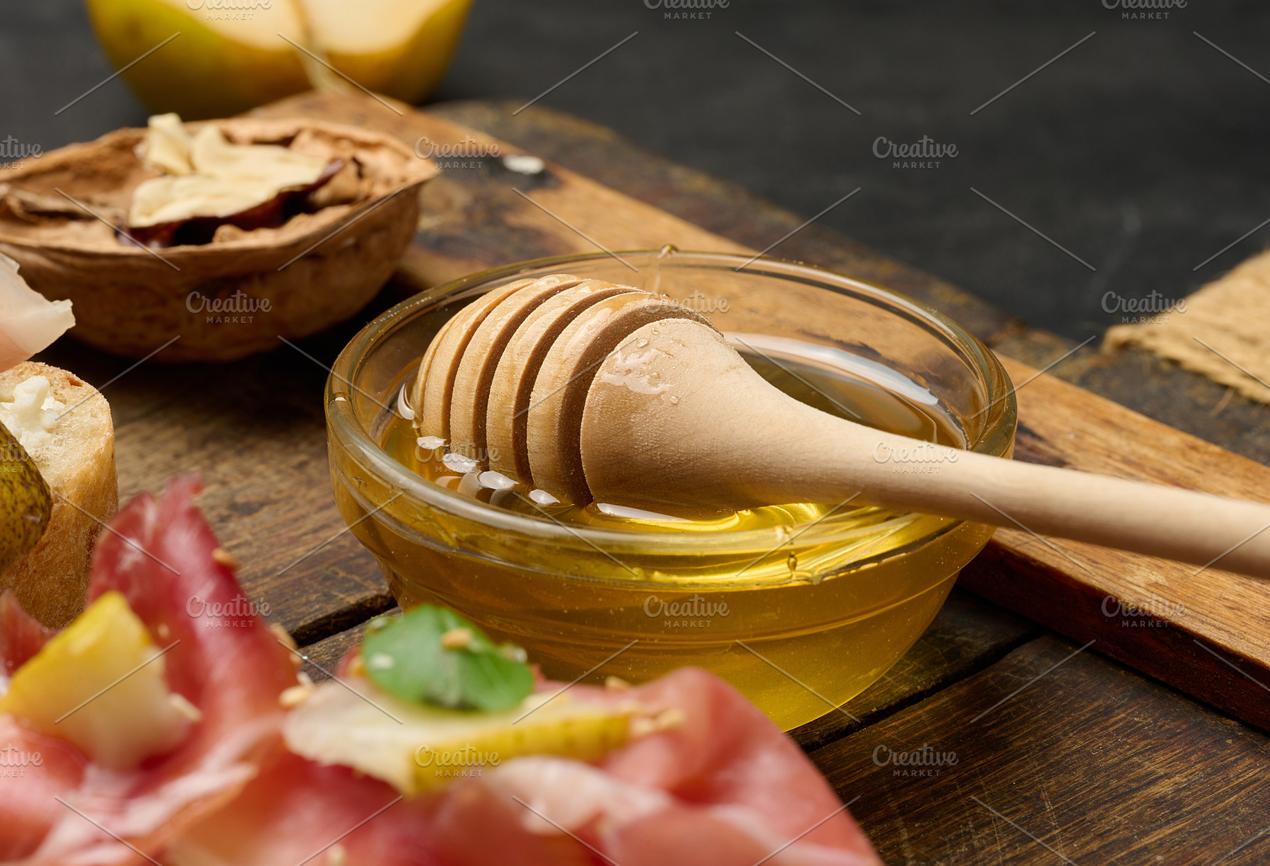 Close-up of a bowl of golden honey and a wooden honey spoon plac, a Food & Drink Photo by ndanko