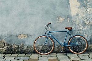 Old retro bike near grey wall background, a Photo by AlyaAnd