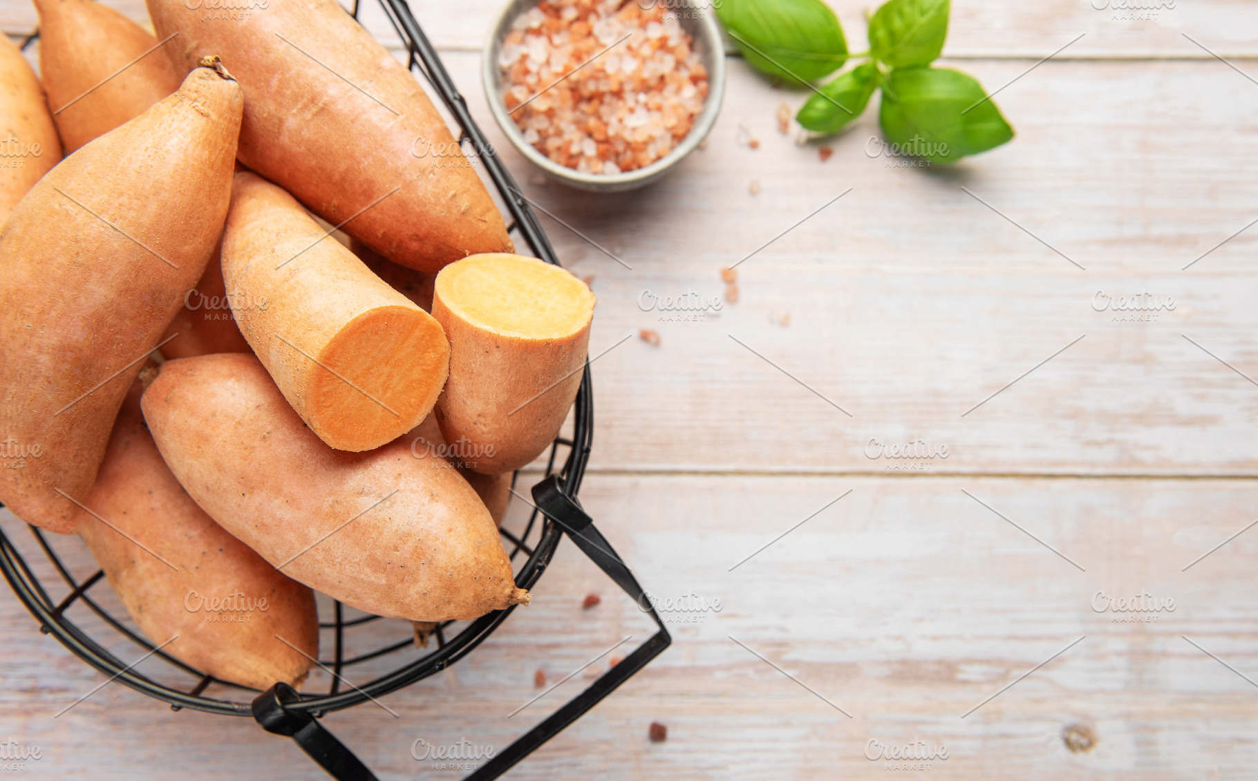 Sweet potato harvest in a basket with pink salt and basil, a Food & Drink Photo by Olena Rudo