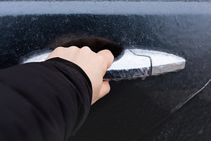 Close-up of a hand gripping an icy car door handle, winter seaso, a Transportation Photo by Ales Munt